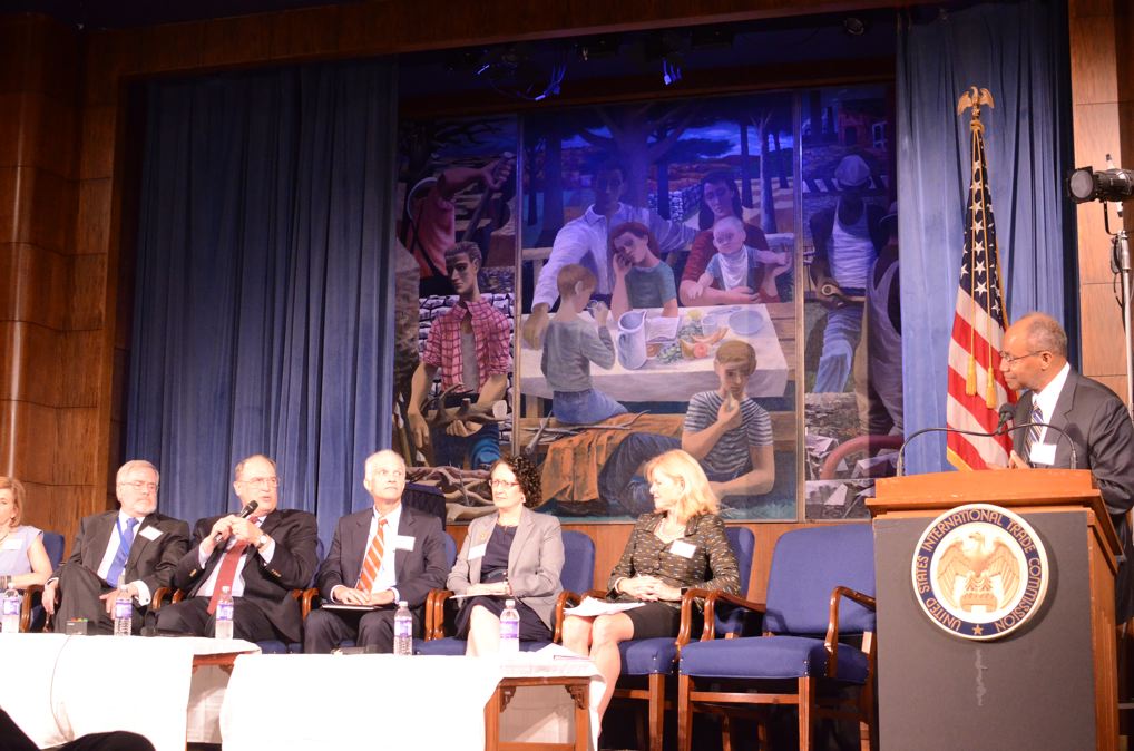 Chairman Irving Williamson introducing members of the 'Institutional Evolution of the Commission' panel.  Shown,  from right to left,  Chairman Williamson, Deanna Okun, Shara Aranoff, Dan Pearson, F. David Foster, Paul Bardos, and Lynn Bragg. 